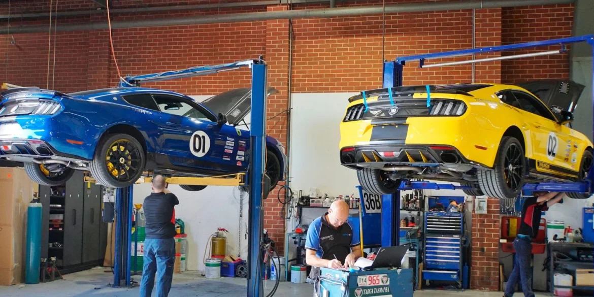 Ford mustangs on floor lift in mechanic shop