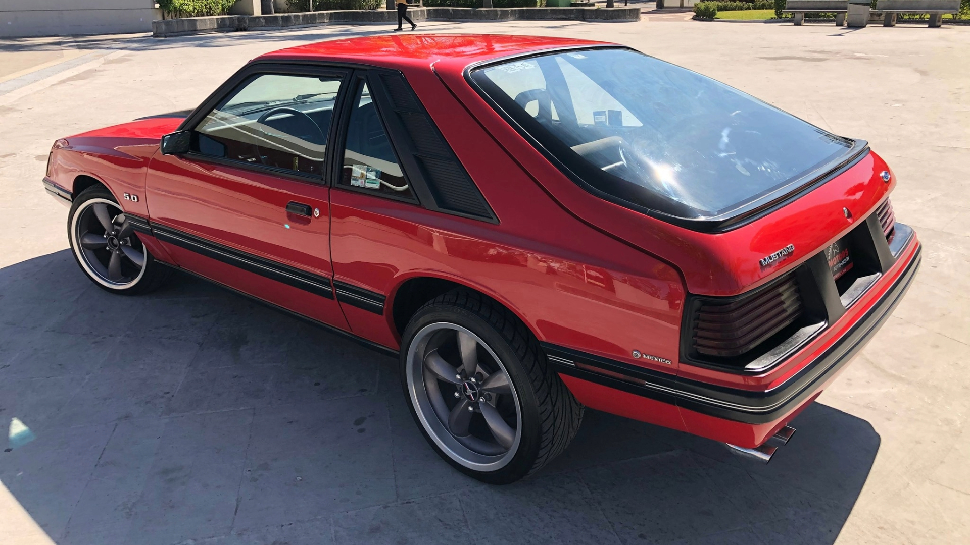 Three-quarter rear view of a red Mexican spec Mustang bubble back.